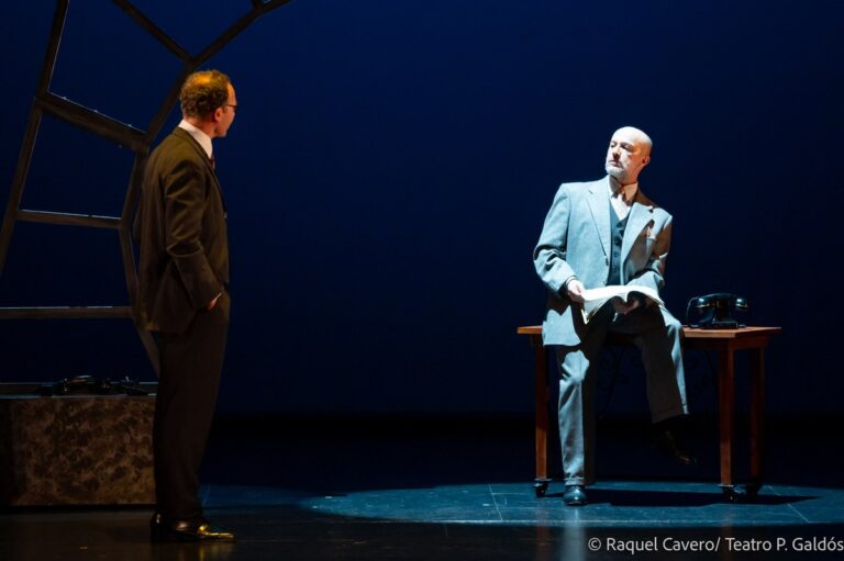Dos intérpretes frente a frente sobre el escenario, uno de traje oscuro y otro de traje claro. Foto: Raquel Cavero / Teatro Pérez Galdós