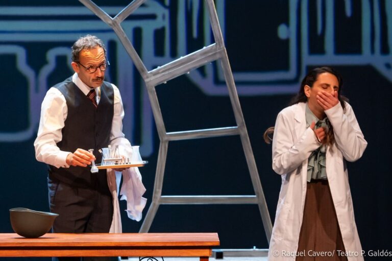 Un intérprete sostiene una bandeja mientras una compañera de bata blanca se lleva la mano a la boca. Foto: Raquel Cavero / Teatro Pérez Galdós