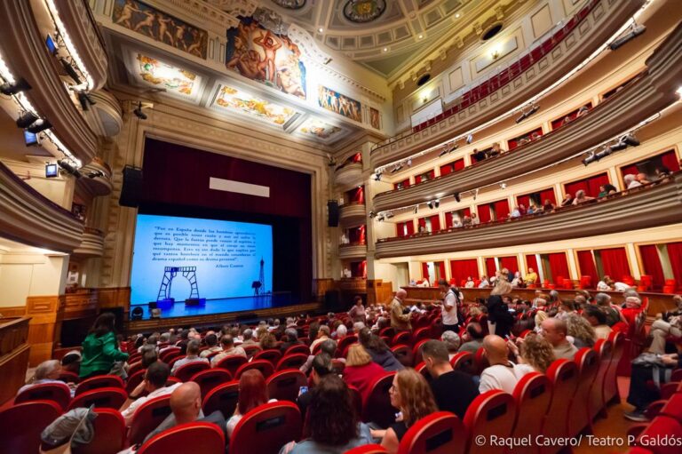 La sala del Teatro Pérez Galdós llena, vista desde el escenario, con la proyección encendida. Foto: Raquel Cavero / Teatro Pérez Galdós