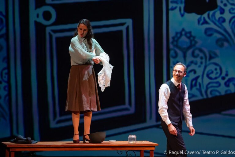 Una intérprete de pie sobre la mesa sostiene un pañuelo mientras un compañero la observa. Foto: Raquel Cavero / Teatro Pérez Galdós