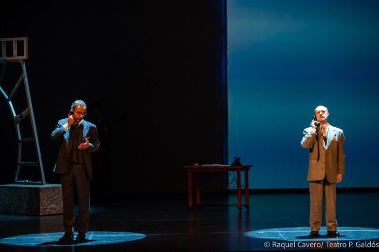 Dos intérpretes muy separados en el escenario, cada uno en su cono de luz, sobre fondo azul. Foto: Raquel Cavero / Teatro Pérez Galdós
