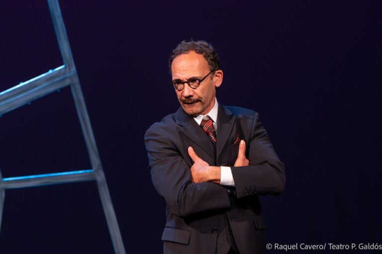 Primer plano de Toni Báez, como Juan Negrín, de brazos cruzados y traje oscuro. Foto: Raquel Cavero / Teatro Pérez Galdós